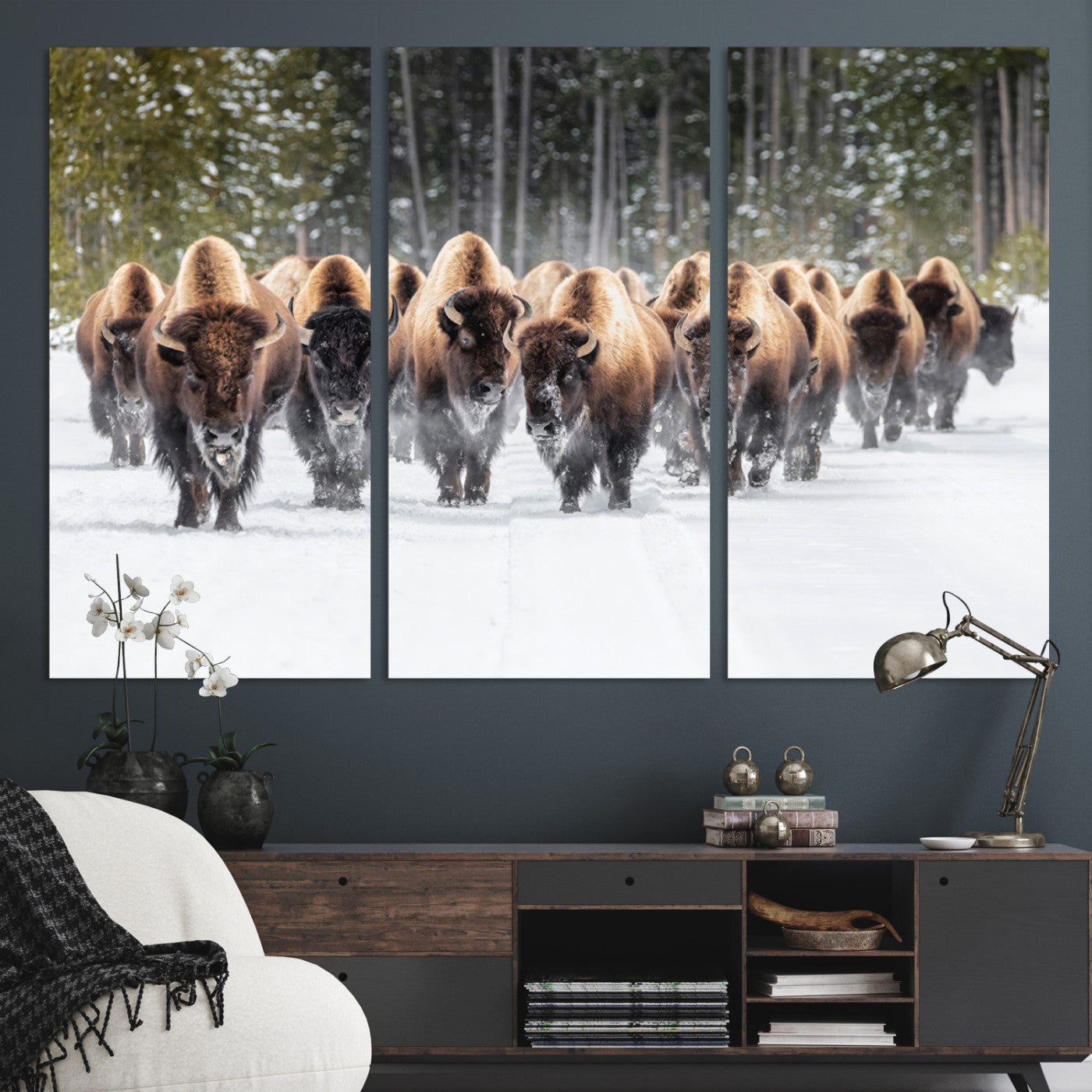 A herd of American bisons walking through a snowy forest path, perfect for rustic cabin or Western-themed wall decor.