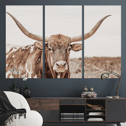 A longhorn cow in soft beige desert tones, standing calmly in open land, perfect for neutral western or rustic farmhouse interiors.