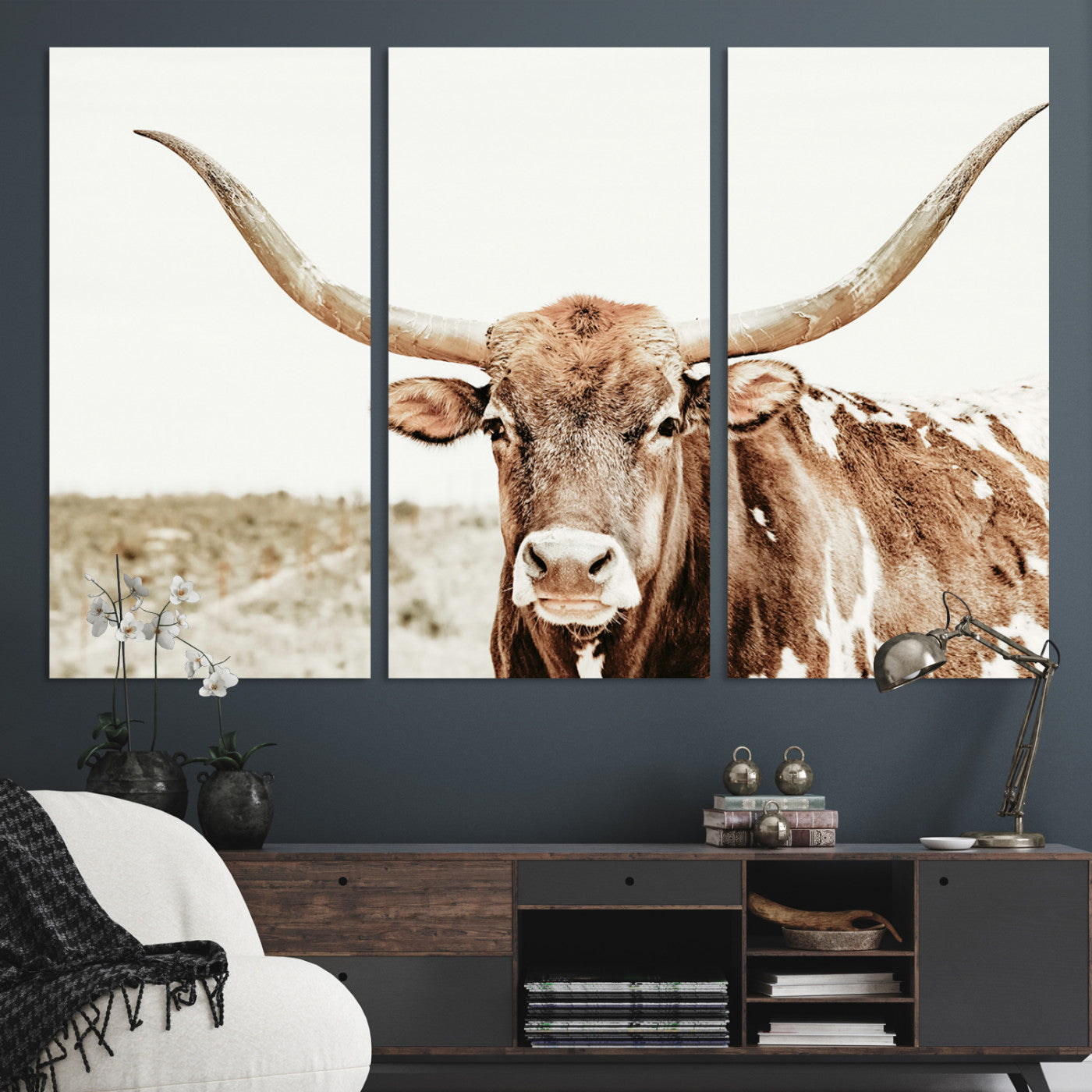 A Texas longhorn bull with wide horns, standing in a dry field under soft light, ideal for rustic farmhouse or western-themed interiors.