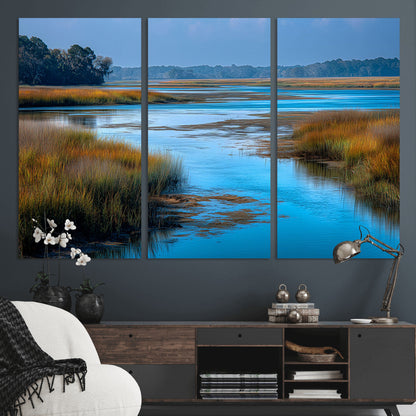 A peaceful marshland scene with calm blue water reflecting the surrounding grasses and trees, capturing the beauty of nature in a serene landscape.