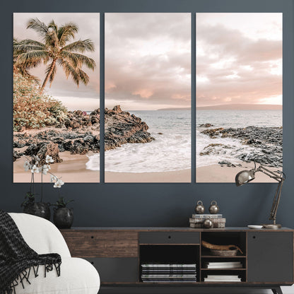 A peaceful beach scene with a palm tree and rocks, soft waves washing onto the shore under a soft pastel sky at sunset.