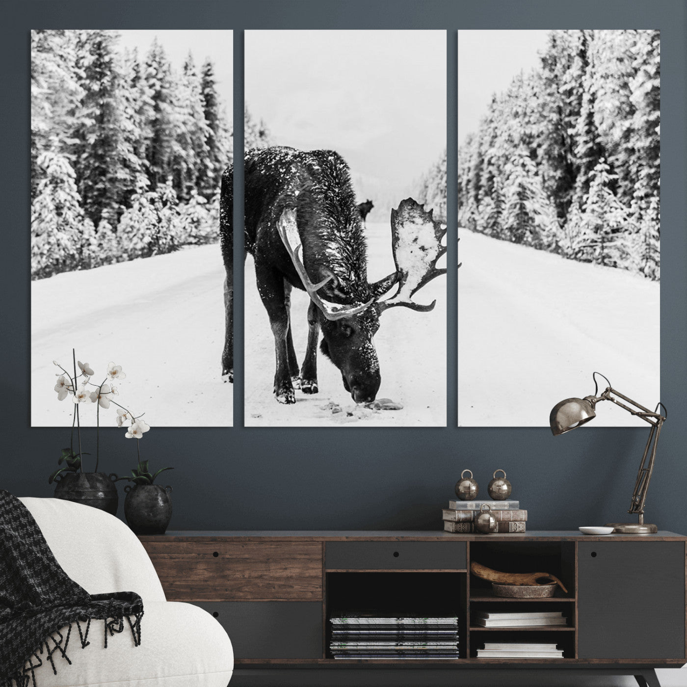 A majestic moose grazing in the snow-covered wilderness, surrounded by snow-covered trees, creating a peaceful winter scene.