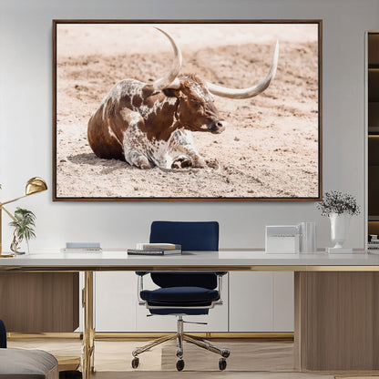 Texas Longhorn bull resting on dusty ground with warm tones, ideal for rustic western or farmhouse-themed wall decor.