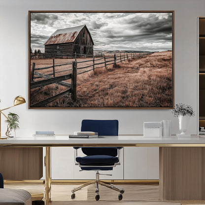 Framed canvas of a rustic barn under a moody sky with weathered fence and dark fields, ideal for farmhouse or rural-style wall decor.