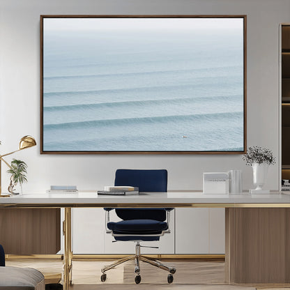 Framed canvas of repeating ocean waves with a distant solo surfer, ideal for minimalist ocean or calm coastal wall decor.