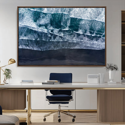 Canvas of aerial ocean waves crashing onto a black sand beach in moody tones, ideal for modern coastal or minimalist home decor.