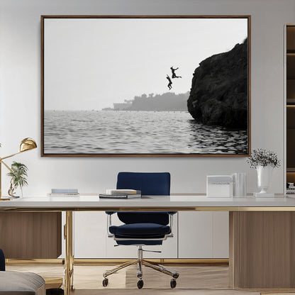 Black and white canvas of two figures cliff jumping into the sea, captured with moody tones, ideal for modern coastal or adventure-themed home decor.   2/2