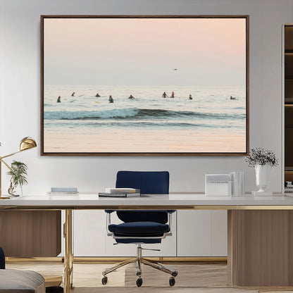 Dreamy photo of surfers waiting on soft pastel waves under a pink sunset sky, ideal for soft coastal minimalist or serene ocean-themed home decor.