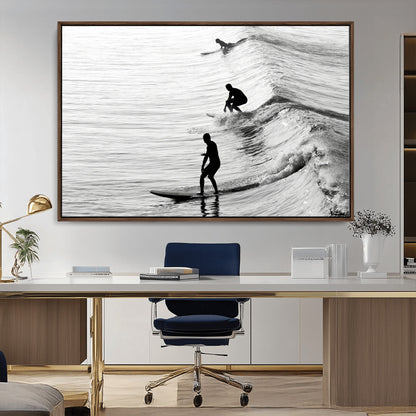 Black and white photo of surfers riding waves in a moody, high-contrast scene, ideal for modern coastal or surf-inspired home decor.