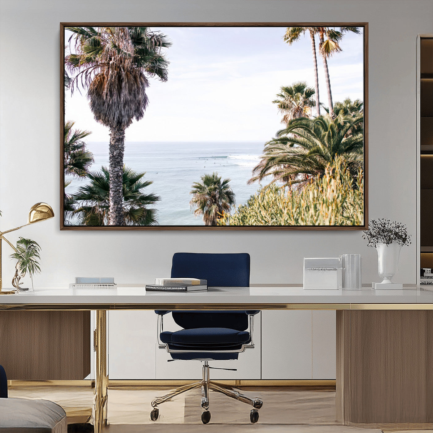 Scenic coastal view with tall palm trees overlooking a calm ocean, soft blue waves, and surfers in the distance, creating a peaceful tropical vibe.