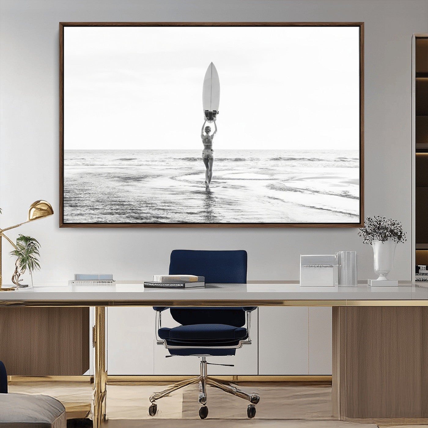Black and white image of a female surfer holding a surfboard above her head while walking toward the ocean, creating a minimalist and bold coastal aesthetic.