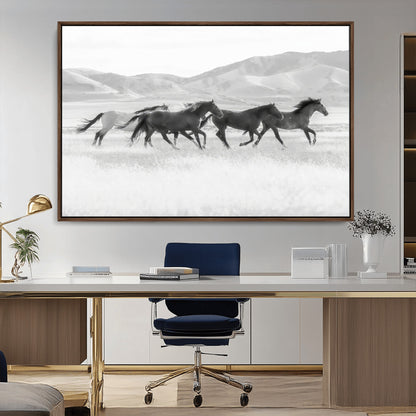 A black and white image of wild horses running freely across an open grassland, capturing the power and beauty of untamed nature in a rustic western setting.