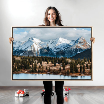 Framed canvas of snowy mountain peaks with pine forest and alpine lake, perfect for winter cabin or wilderness-inspired home decor.