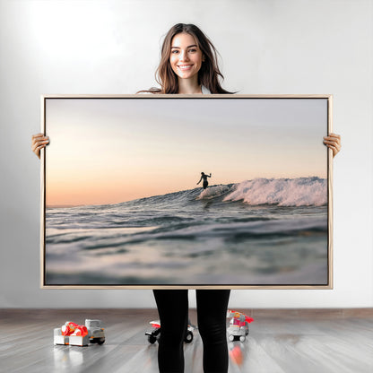 Framed canvas of a female surfer balancing on a wave at sunset, perfect for serene surf or ocean-inspired coastal decor.