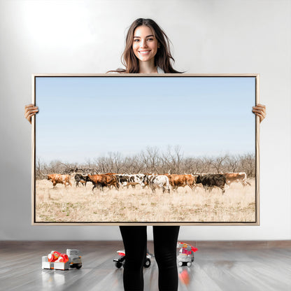 Framed wall art of Texas longhorn cattle walking through a dry, neutral-toned prairie, perfect for rustic farmhouse or western-themed home decor.