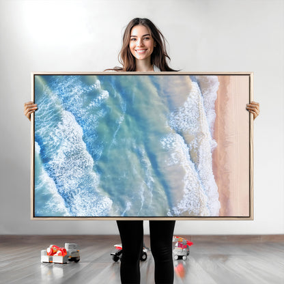 Aerial photo of soft blue waves meeting sandy shore, perfect for modern coastal or beach-themed decor with a light and tranquil aesthetic.