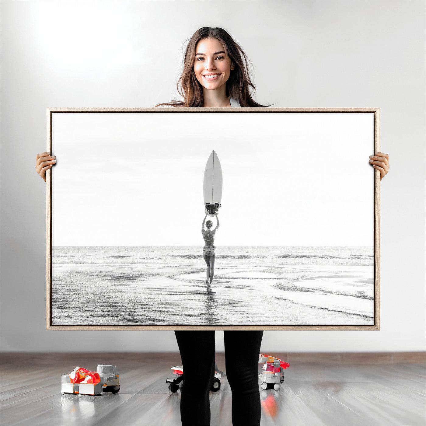 Black and white image of a female surfer holding a surfboard above her head while walking toward the ocean, creating a minimalist and bold coastal aesthetic.