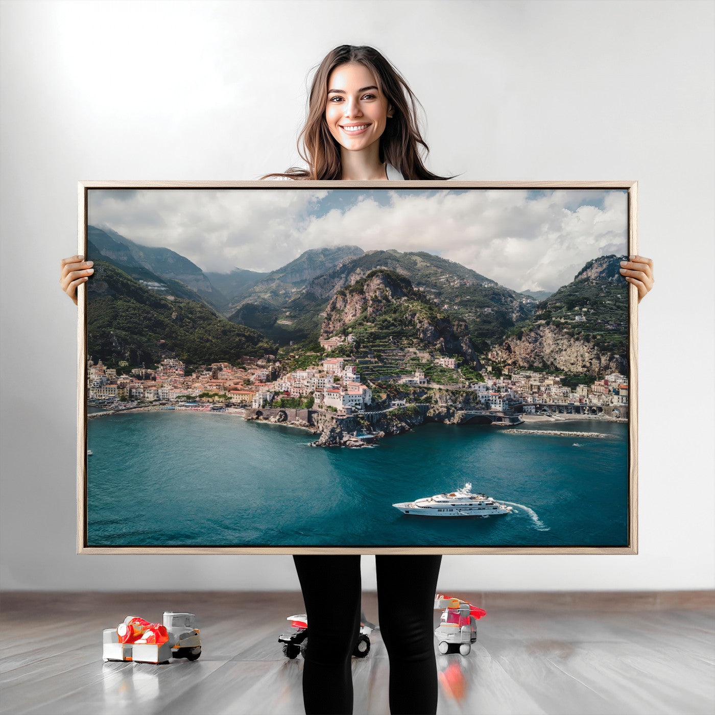 Aerial view of Amalfi Coast, Italy, with colorful hillside houses, lush green mountains, and a luxury yacht sailing in turquoise waters.