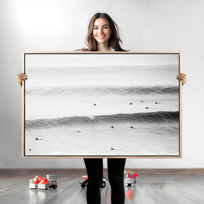 A monochrome photograph of swimmers gliding through gentle ocean waves, evoking a sense of calm and movement.