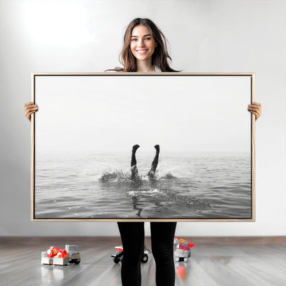 A black and white minimalist water scene capturing a playful splash as a swimmer dives upside down, creating a carefree and artistic aquatic aesthetic.
