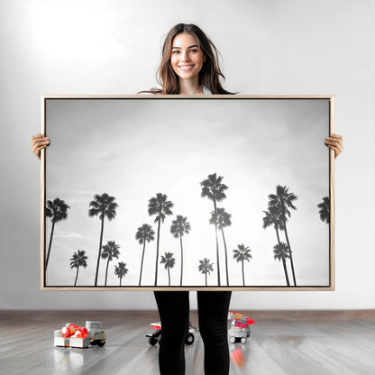 A black and white minimalist scene featuring tall palm trees silhouetted against a bright sky, creating a dreamy and timeless tropical aesthetic.
