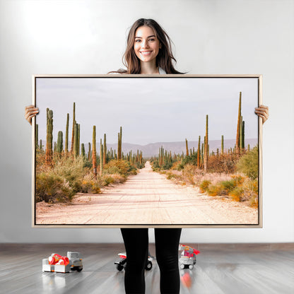 A desert road lined with saguaro cacti under a golden sky, creating a warm southwestern feel, perfect for boho or rustic decor.