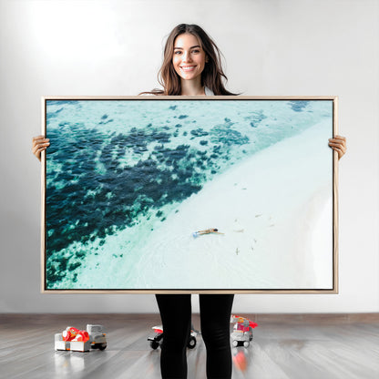 Canvas featuring an aerial view of a swimmer in shallow turquoise waters with coral patterns, ideal for tropical coastal home decor.