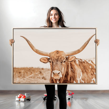 A longhorn bull standing proudly in a sunlit desert field with warm neutral tones, ideal for rustic western or farmhouse interiors.