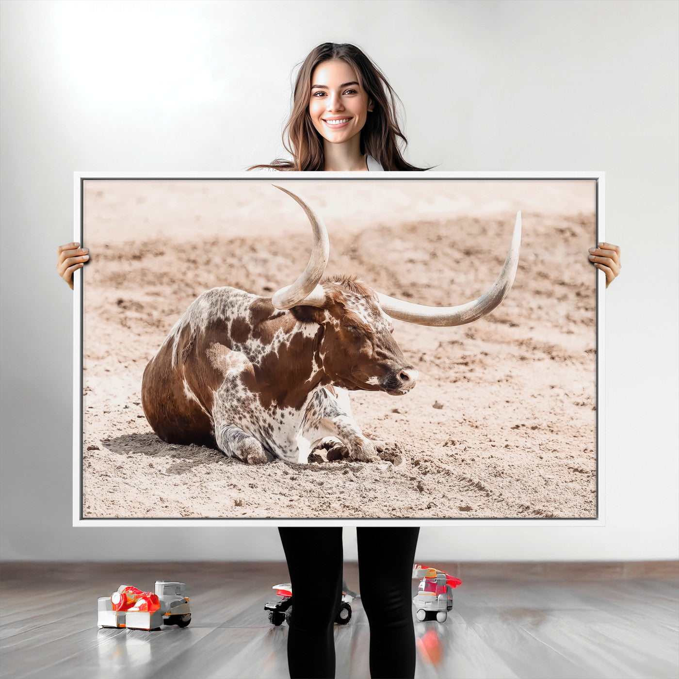 Texas Longhorn bull resting on dusty ground with warm tones, ideal for rustic western or farmhouse-themed wall decor.