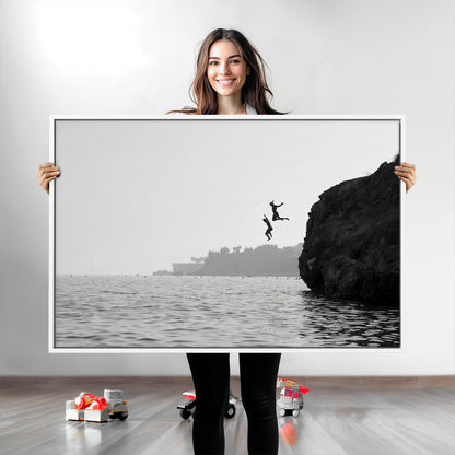 Black and white canvas of two figures cliff jumping into the sea, captured with moody tones, ideal for modern coastal or adventure-themed home decor.   2/2