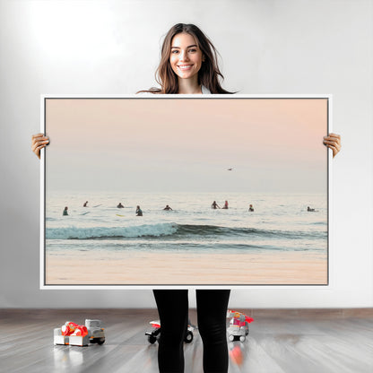 Dreamy photo of surfers waiting on soft pastel waves under a pink sunset sky, ideal for soft coastal minimalist or serene ocean-themed home decor.