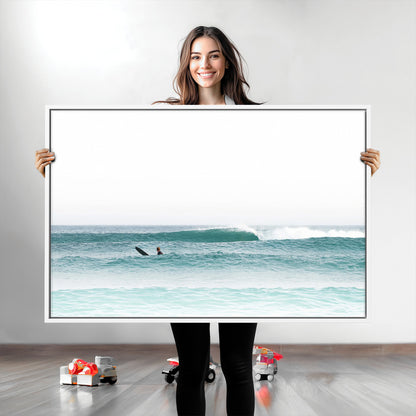 Minimalist photo of a lone surfer on calm aqua waves under bright sky, perfect for Scandinavian coastal or serene ocean-inspired home decor.