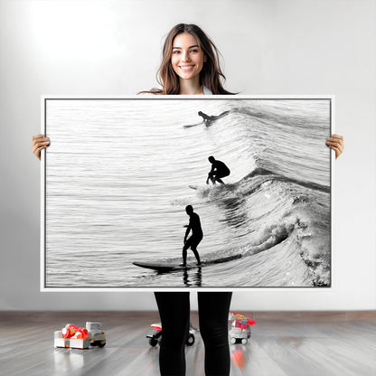 Black and white photo of surfers riding waves in a moody, high-contrast scene, ideal for modern coastal or surf-inspired home decor.