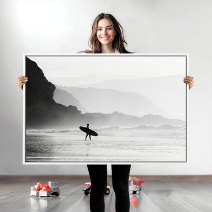 A lone surfer walking along a misty beach with cliffs in the background, carrying their board, capturing a serene and minimal ocean moment.