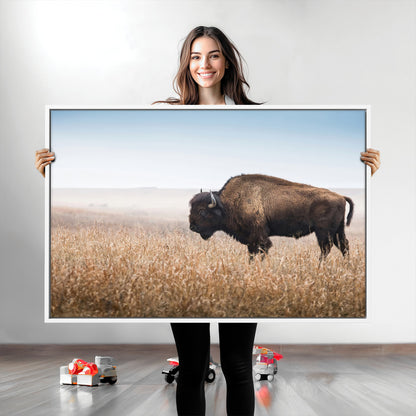 A majestic bison standing in an open prairie field, its strong form blending into the golden grass under a vast blue sky, evoking the wild spirit of the American plains.