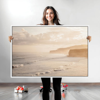 Golden hour seascape with misty cliffs and gentle waves rolling towards the shore, capturing a tranquil and warm coastal atmosphere.