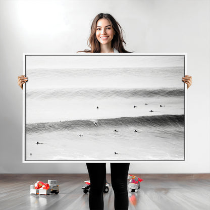 A monochrome photograph of swimmers gliding through gentle ocean waves, evoking a sense of calm and movement.