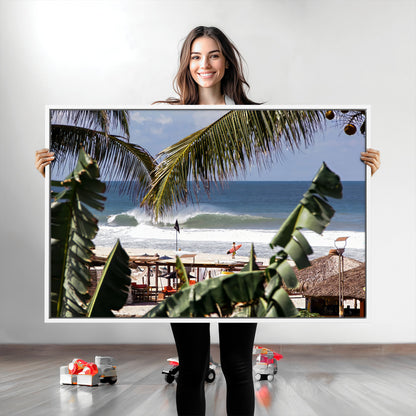 Canvas wall art of a tropical surf scene framed by palm trees, with a surfer on the shore and waves rolling in, ideal for beach-themed decor.