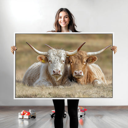 Two cows laying closely in a dry grassy field, captured in soft light, perfect for rustic farmhouse or western style home decor.