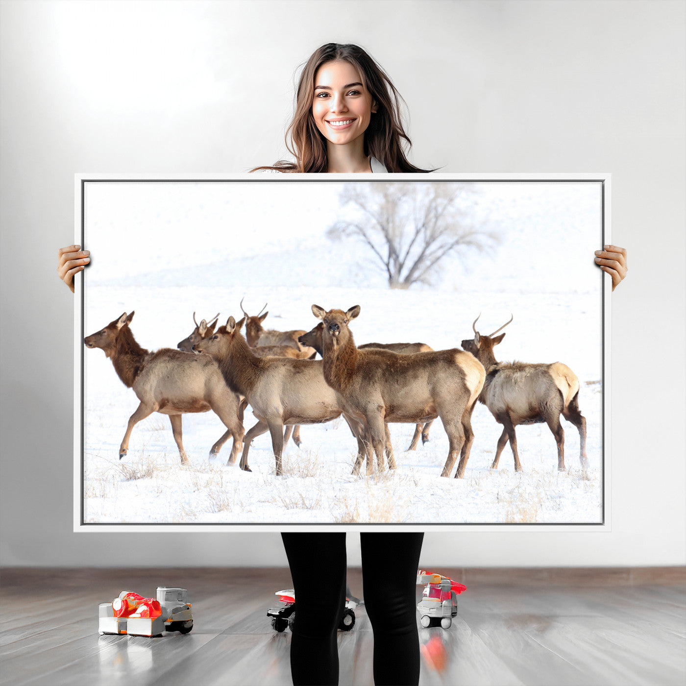 A group of elk standing on snowy terrain with a tree in the background, perfect for rustic or lodge-style winter wall decor.