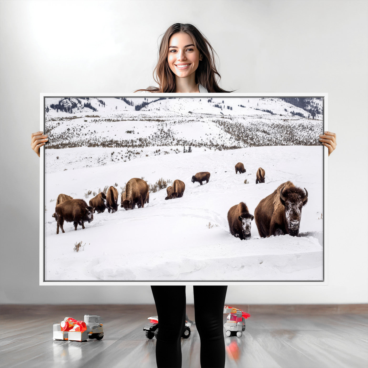A herd of bison walking through deep snow in a mountain valley, perfect for rustic, cabin or western-themed wall decor.