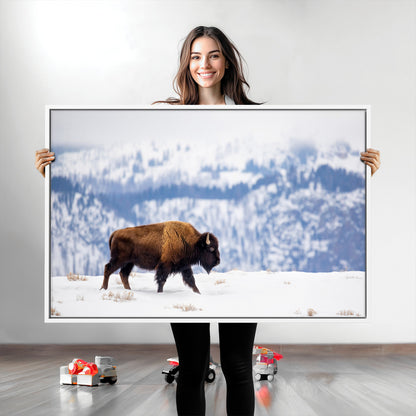 A lone bison walks across snowy ground with blue-toned mountain range behind, ideal for rustic or western farmhouse interiors.