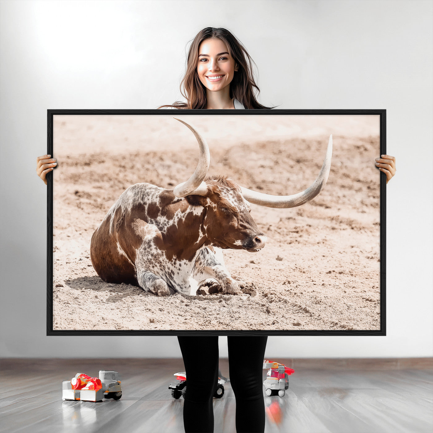 Texas Longhorn bull resting on dusty ground with warm tones, ideal for rustic western or farmhouse-themed wall decor.