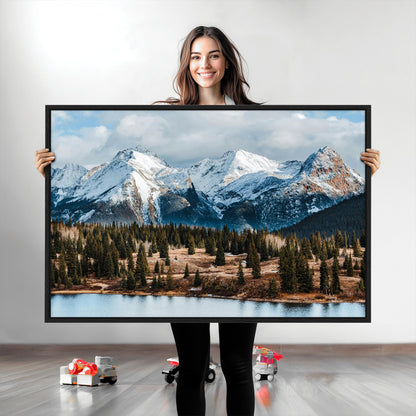 Framed canvas of snowy mountain peaks with pine forest and alpine lake, perfect for winter cabin or wilderness-inspired home decor.