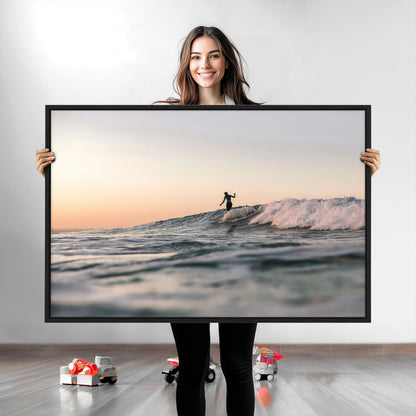 Framed canvas of a female surfer balancing on a wave at sunset, perfect for serene surf or ocean-inspired coastal decor.