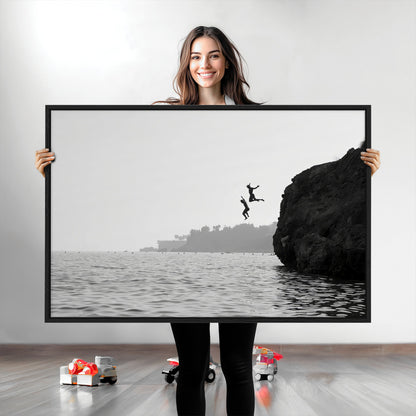 Black and white canvas of two figures cliff jumping into the sea, captured with moody tones, ideal for modern coastal or adventure-themed home decor.   2/2