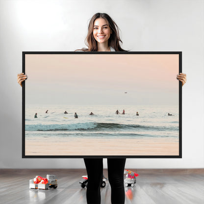 Dreamy photo of surfers waiting on soft pastel waves under a pink sunset sky, ideal for soft coastal minimalist or serene ocean-themed home decor.