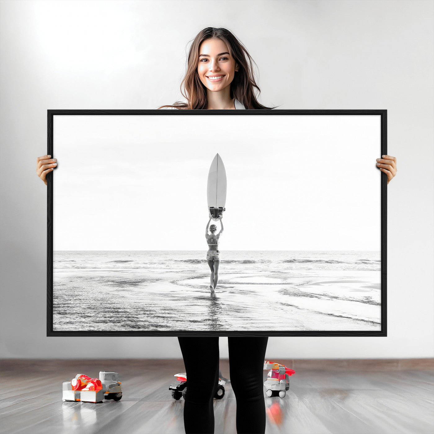 Black and white image of a female surfer holding a surfboard above her head while walking toward the ocean, creating a minimalist and bold coastal aesthetic.
