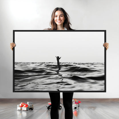 Black and white ocean with a hand making a surfer sign among dark waves, creating a dramatic and minimalist seascape with bold contrast.
