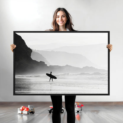 A lone surfer walking along a misty beach with cliffs in the background, carrying their board, capturing a serene and minimal ocean moment.